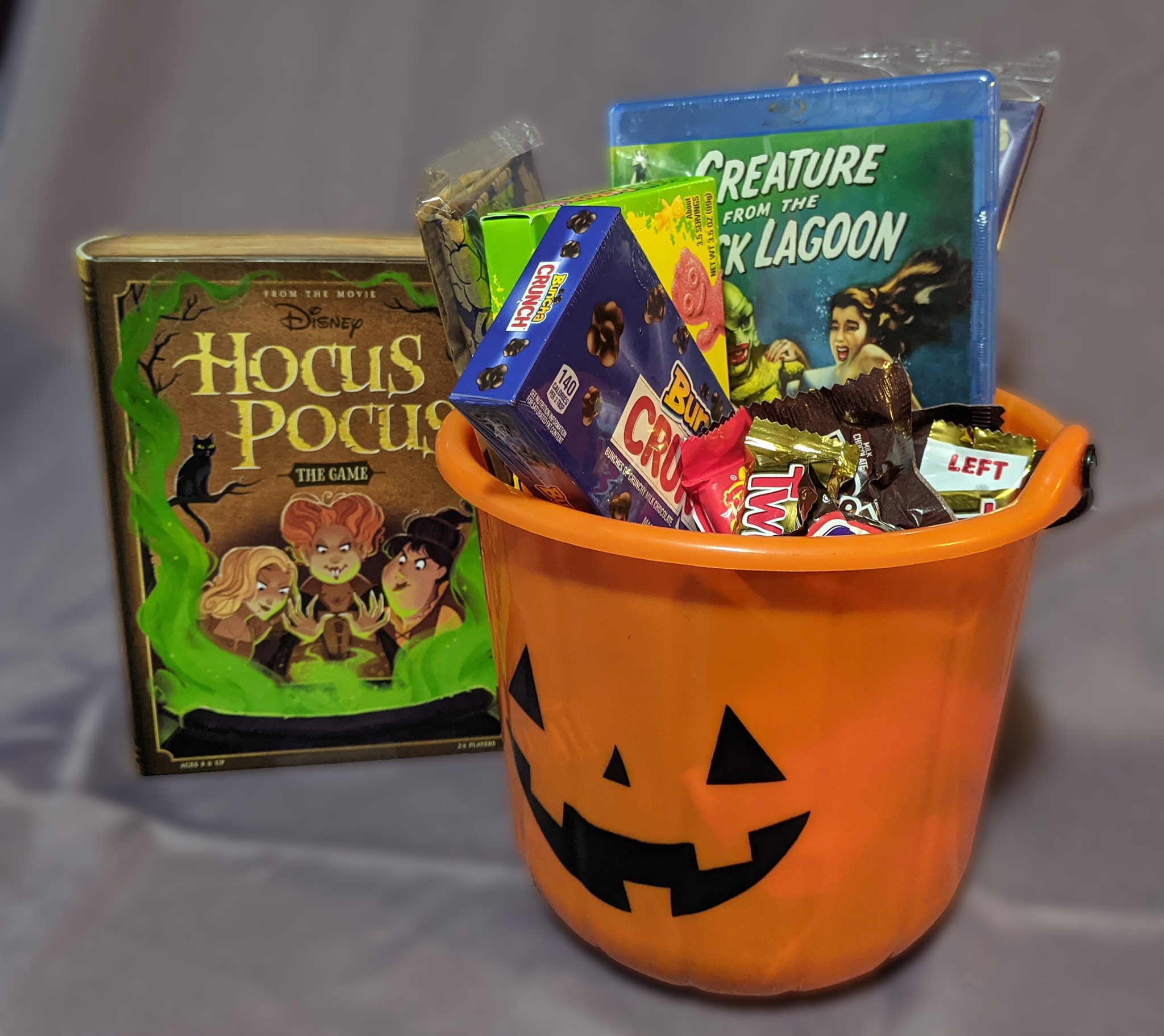 Hocus Pocus the Game and A jack-o-lantern bucket filled with candy, popcorn, and a Creature from the Black Lagoon Blu-ray